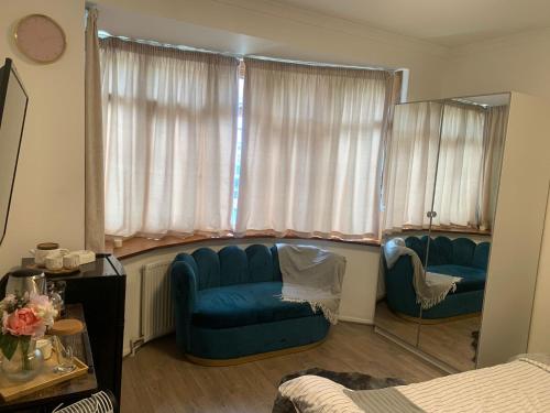 mayfair في Northolt: غرفة معيشة مع أريكة زرقاء ونافذة