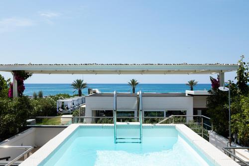 a swimming pool on the roof of a house with the ocean at Boutique Hotel Esplanade in Paestum