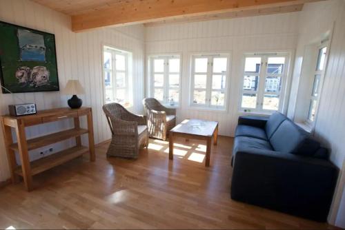 a living room with a blue couch and a table at Day Dream Hellnar in Snæfellsbær