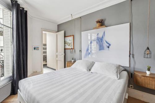 a bedroom with a large white bed and a window at Convention - Saint Lambert 1 bdr in Paris