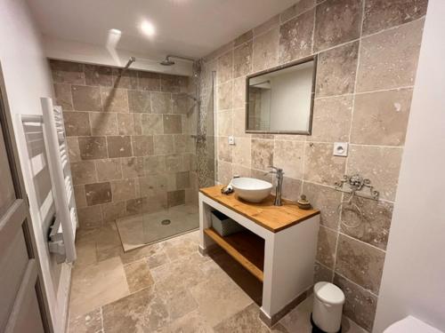 une salle de bain avec un lavabo et un miroir dans l'établissement Le Mas du Pigeonnier, à Réauville