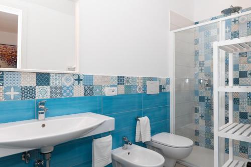 a blue and white bathroom with a sink and a toilet at Villa Harmony Sorrento in Meta
