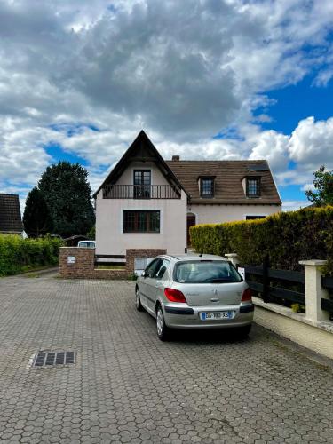 une voiture en argent garée devant une maison dans l'établissement Villa near CDG Paris aeroport, à Arnouville-lès-Gonesse