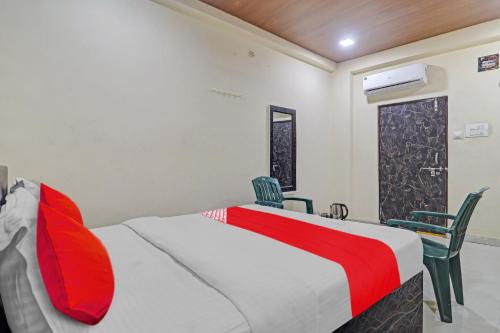 a bedroom with a large bed and two chairs at OYO Flagship Rks Residency in Shamshabad