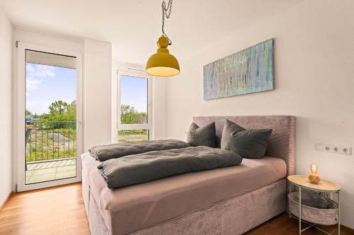 een slaapkamer met 2 kussens op een bed met een raam bij SEEzauber in dirketer Seenähe in Friedrichshafen