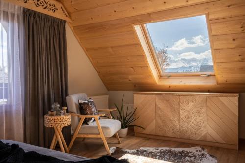 Zimmer mit einem Fenster, einem Sofa und einem Stuhl in der Unterkunft U Dzikosa in Ząb