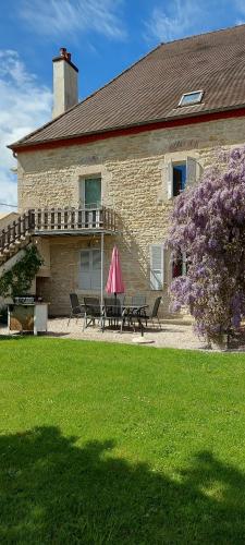 a house with a table and benches in front of it at Crisoline in Longwy-sur-le-Doubs