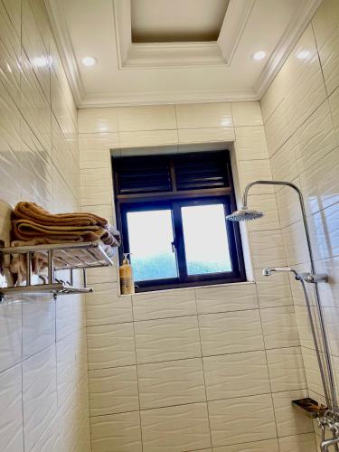 een badkamer met een douche en een raam bij Sweet home apartment in Namulanda