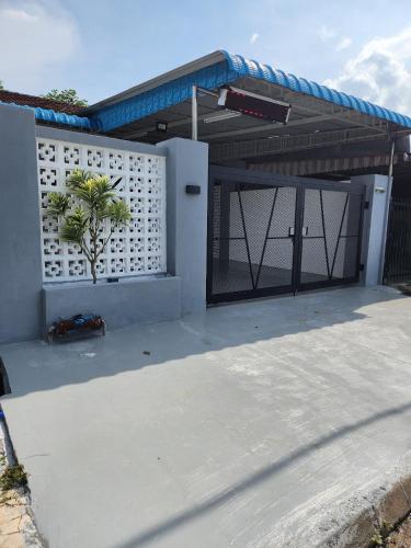 a house with a garage door with a palm tree at Sun Shine Home by Ipoh Maju Stay in Ipoh