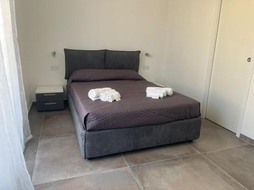 ein Schlafzimmer mit einem Bett mit zwei Handtüchern darauf in der Unterkunft S'Aneddu e Oro in Alghero