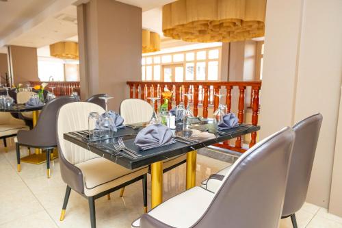 a dining room with a table and chairs at M Hotel Kigali in Kigali
