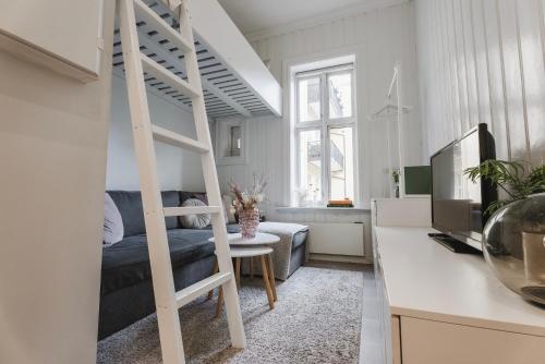 1 cama blanca elevada en una sala de estar con sofá en Studio apartment in central Oslo en Oslo