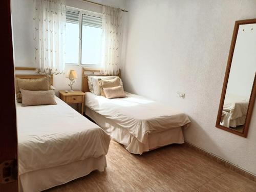 twee bedden in een kamer met een spiegel bij Reina Victoria 2 bed apartment in Rojales
