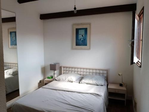 - une chambre dotée d'un lit avec des draps blancs dans l'établissement Appartement T3 dans village Naturiste en bord de Mer, à Leucate
