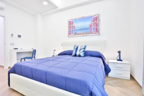 - une chambre blanche avec un lit bleu et un bureau dans l'établissement Casa NordOvest Cheerful Apartment, à Salerne
