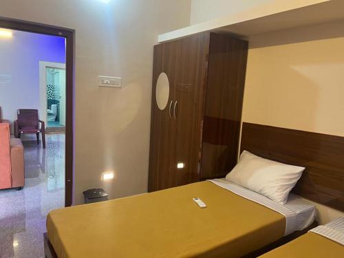a bedroom with a bed with a wooden head board at Rt Service Apartments Hotel in Velankanni