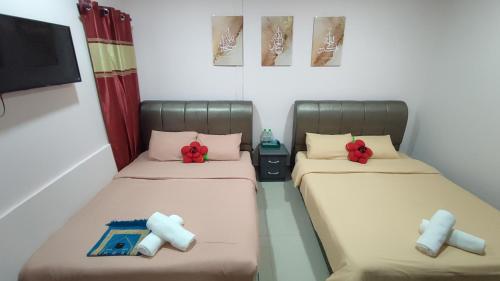 Dos camas en una habitación con arcos rojos. en Santai Desa Chalet musleem 0nly, en Brinchang