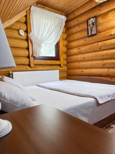 1 dormitorio con 2 camas en una cabaña de madera en Cottage Kalinka en Bukovel