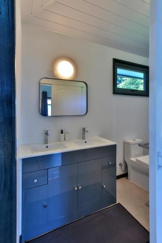 a bathroom with a sink and a mirror at Sublime Tahiti Beach Retreat in Mataiea