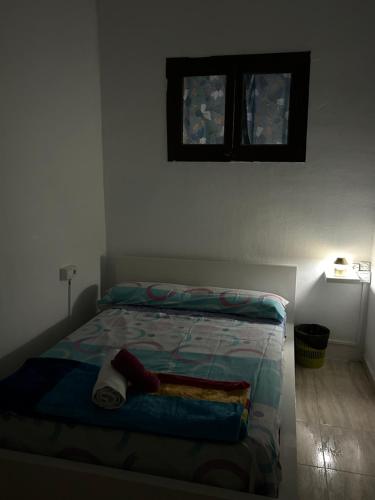 ein Bett in einem Schlafzimmer mit zwei Fenstern an der Wand in der Unterkunft SAN Rafael in Barcelona