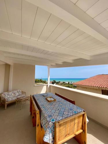 balcone con tavolo e vista sull'oceano di La Terrazza di Nonna Maria a Realmonte