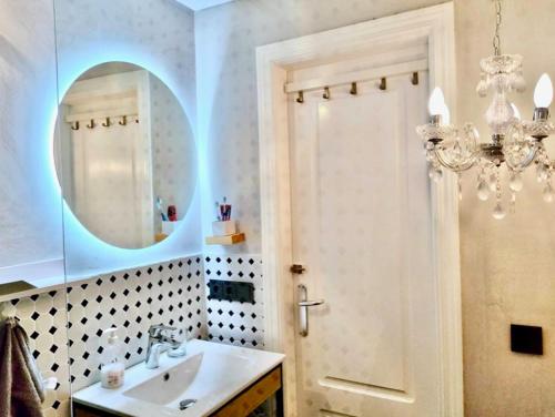 a bathroom with a sink and a mirror and a chandelier at My Space on the Beach, Luxury Apartment in Casares