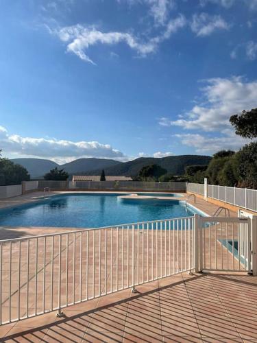 - une piscine sur une terrasse avec une clôture dans l'établissement Très joli appartement T2 40 m2 avec piscine, à La Croix-Valmer