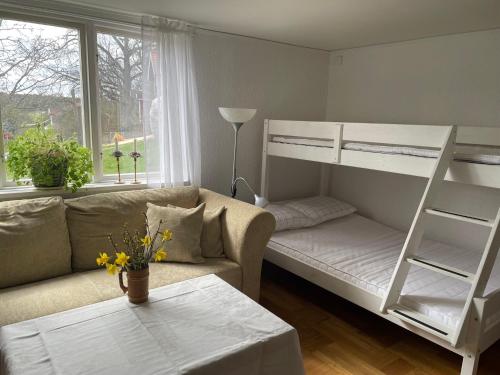 salon z łóżkiem piętrowym i kanapą w obiekcie Karlshamn 1 Sankt Anna Söderköping w mieście Söderköping