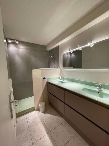 une salle de bain avec deux lavabos et un grand miroir dans l'établissement Très joli appartement T2 40 m2 avec piscine, à La Croix-Valmer