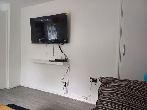 a living room with a tv on a white wall at Beautiful maisonette in Leeds