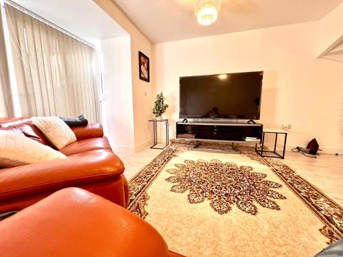 sala de estar con sofá y TV de pantalla plana en King-Size Bedroom en Kent