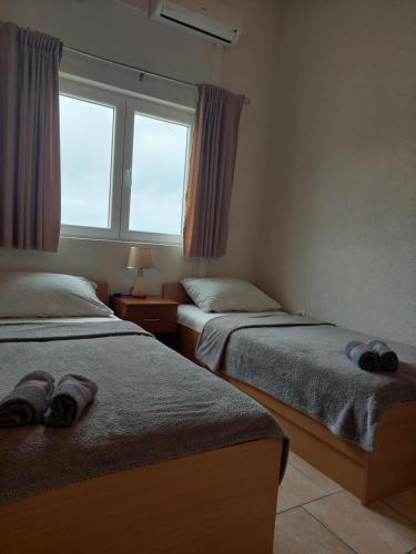 a bedroom with two beds and a window at Royal Apartments in Neum