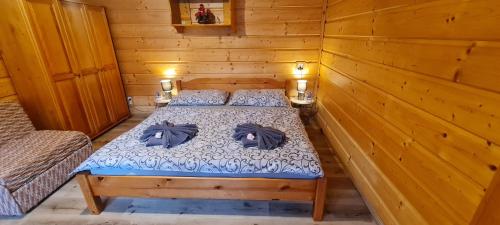 a bedroom with a bed in a wooden cabin at Penzion na Lůkách in Horní Bečva