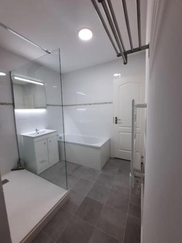 La salle de bains est pourvue d'une douche en verre, d'une baignoire et d'un lavabo. dans l'établissement Appartement Calais, à Calais
