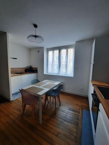 une cuisine avec une table et des chaises dans une pièce dans l'établissement Appartement Calais, à Calais