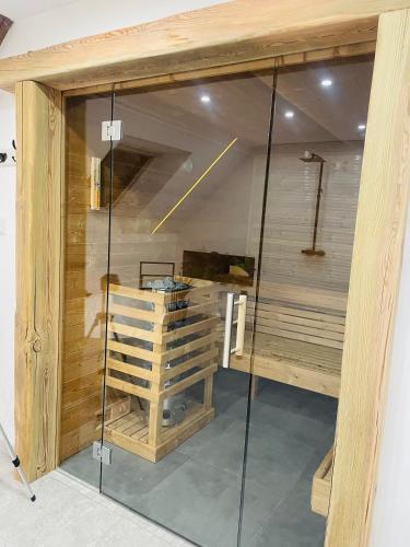 a sauna with a glass door in a room at Maison Gite Chez Nounou sauna jacuzzi jardin arboré in Etting