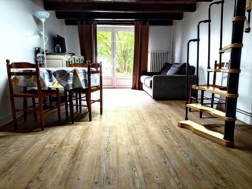 Chez Jul في Bulligny: غرفة معيشة مع أرضية خشبية وأريكة