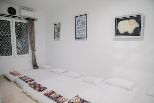 uma sala de estar branca com um sofá branco num quarto em Kirana Guest House Bogor em Bogor
