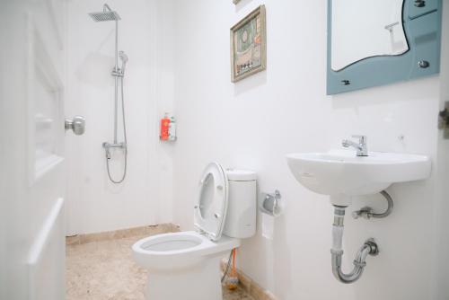 a bathroom with a toilet and a sink at Kirana Guest House Bogor in Bogor