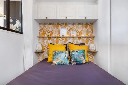 une chambre avec des oreillers jaunes et bleus sur un lit dans l'établissement Une pépite face à la mer avec accès direct plage, au Cap d'Agde