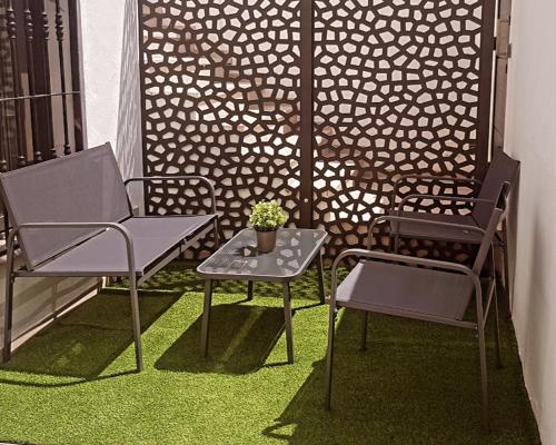 a patio with two chairs and a table with a potted plant at Apartamento Daniella Nerja in Nerja
