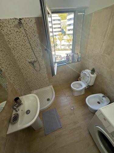 y baño con lavabo, aseo y ducha. en Gafko Apartments Currila Beach, en Durrës