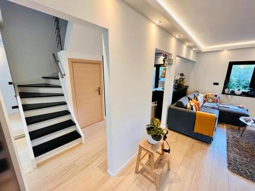 a living room with a couch and a staircase at Town house with garden - 1 room with shared bathroom in Brussels