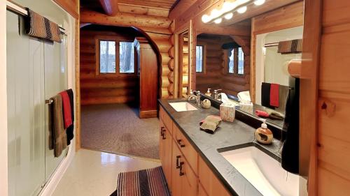 uma casa de banho com um lavatório e um espelho num chalé de madeira em Grand View Log Cabin em Seeley