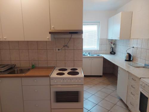 a kitchen with a white stove and a sink at Royal Apartments in Neum