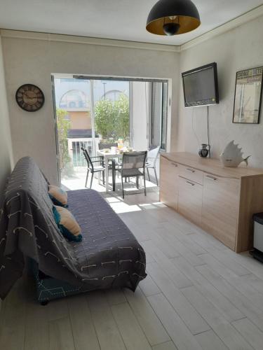un salon avec un canapé, une télévision et une table dans l'établissement Sète climatisé 200 m plage parking, à Sète
