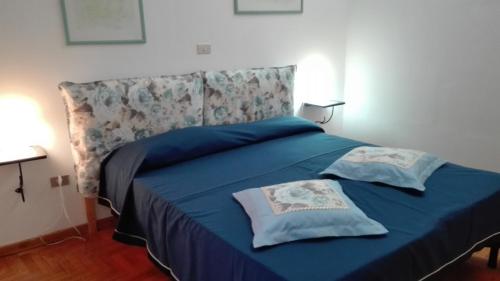 a blue bed with two pillows on top of it at La grangia in Ferentino