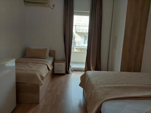 a room with two beds and a window at Royal Apartments in Neum
