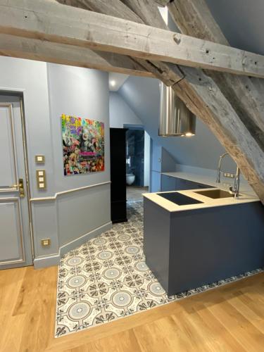 une cuisine avec un comptoir et un tableau au mur dans l'établissement Villa Du Temple-Parking-Climatisation-Ascenseur-Wifi-Netflix-Hypercentre, à Auxerre