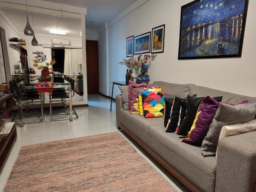 a living room with a couch and a dining room at Quarto e banheiro privativos com garagem fechada em apartamento aconchegante em Jardim da Penha in Vitória